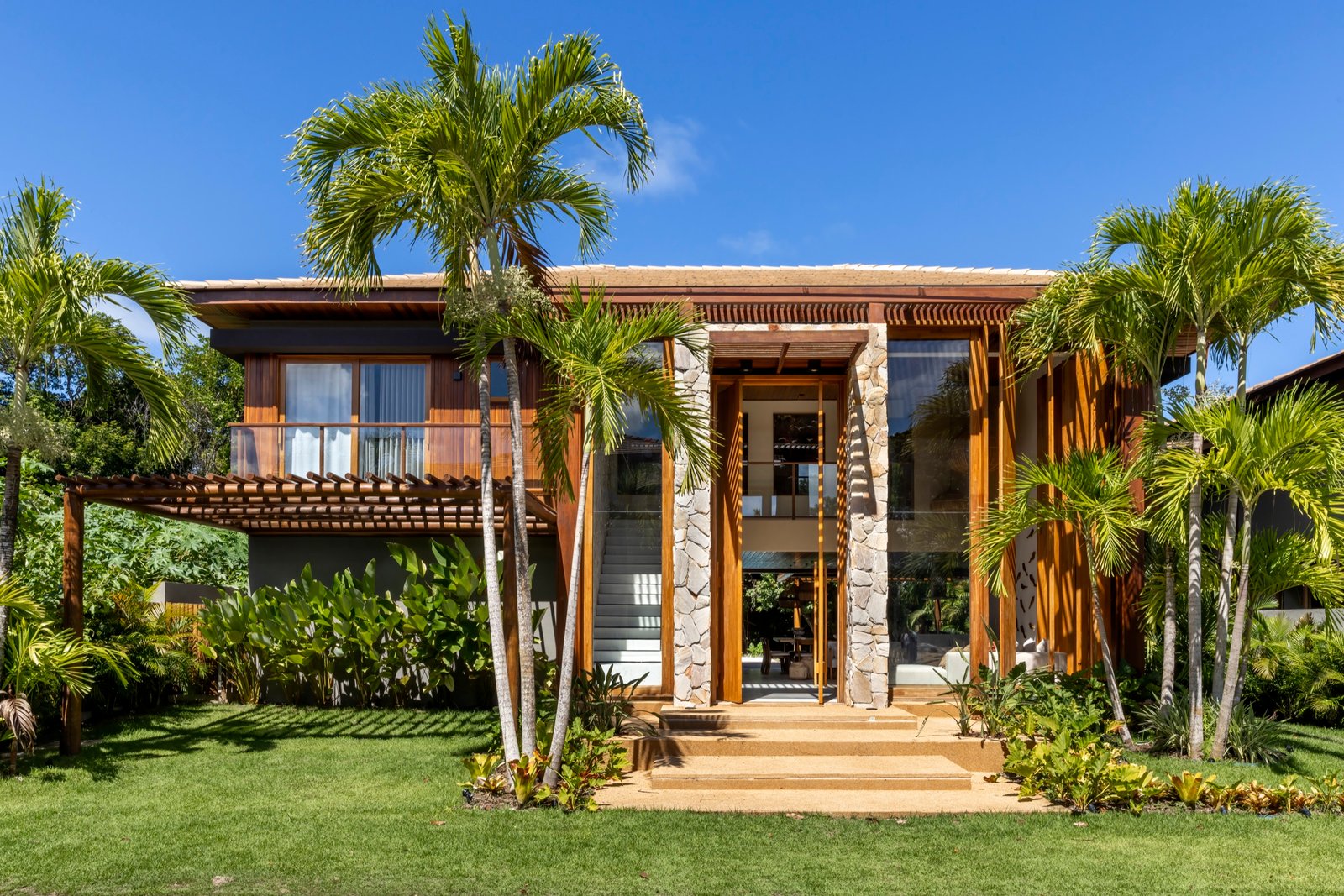 Fachada frontal da Casa Pássaros em meio ao paisagismo